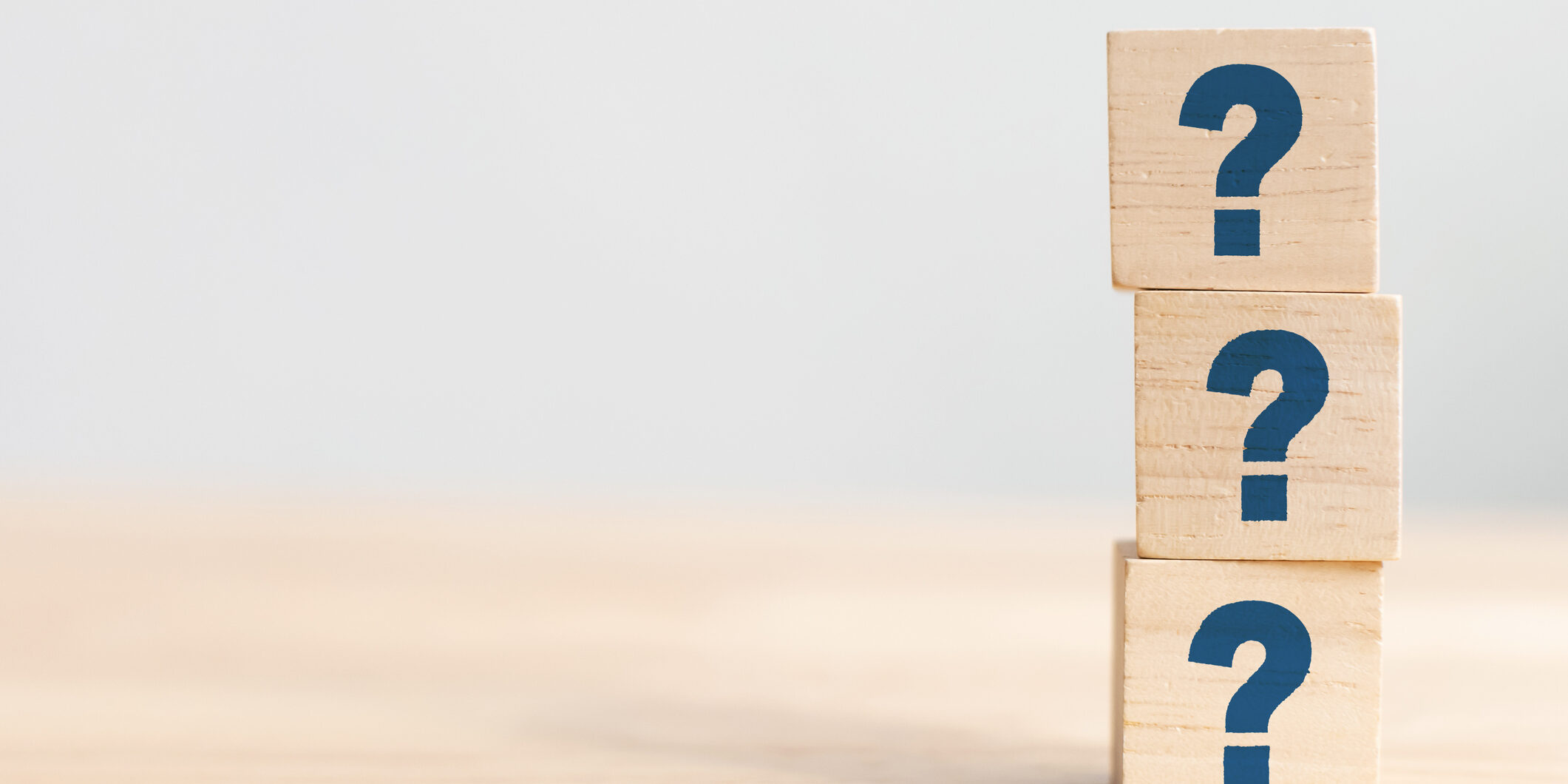 Wooden cube block shape with sign question mark symbol on wood table