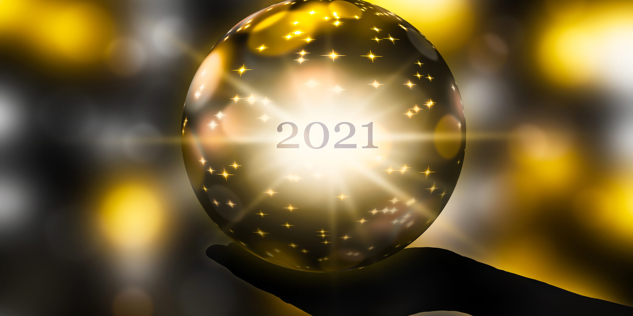 crystal ball in a hand, prediction for new year 2021 on abstract shiny blurred background