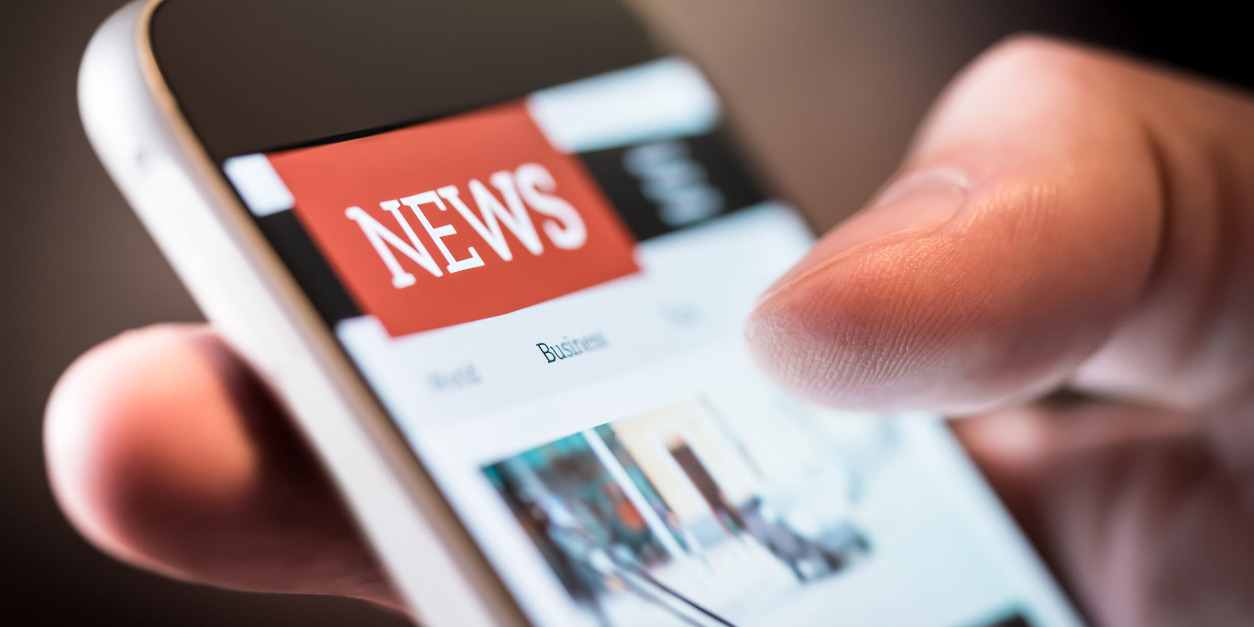 Online news in mobile phone. Close up of smartphone screen. Man reading articles in application. Hand holding smart device. Mockup website.