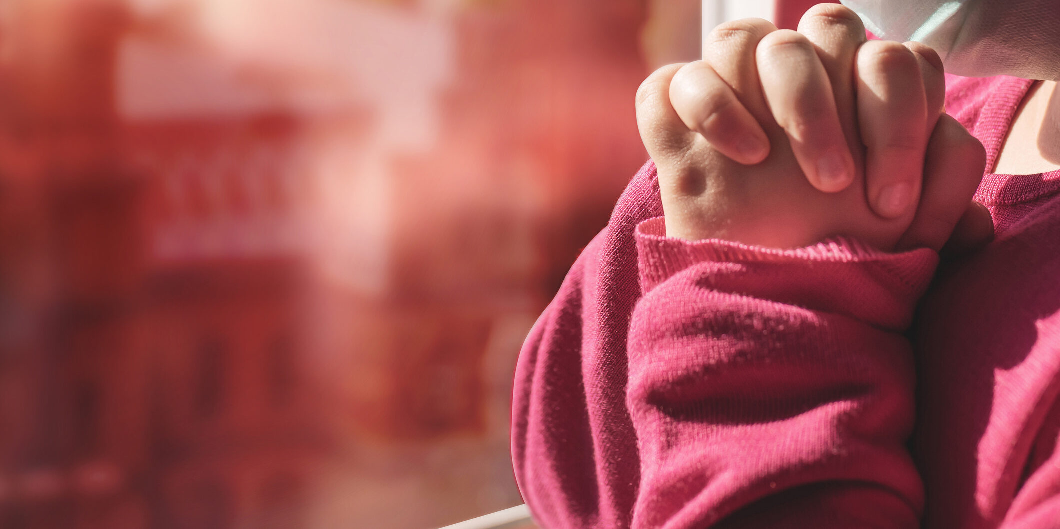 A little girl watching the city in Ukraine during the Ukraine – Russia war, praying for the war to end.